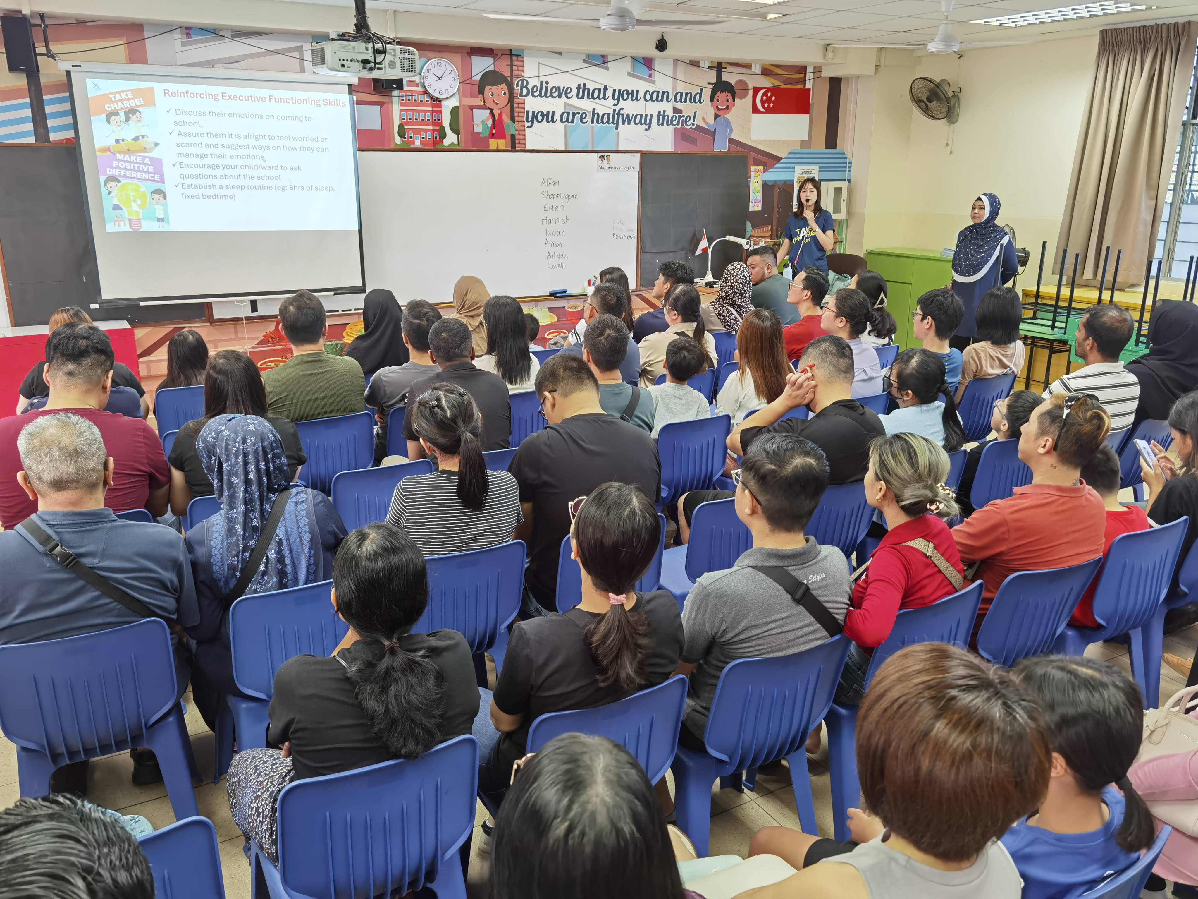 Parents gathered together listening to the briefing